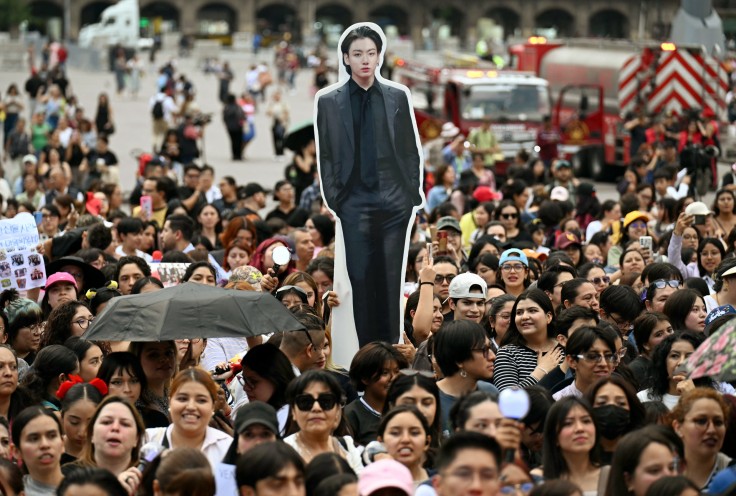 Fans of South Korean K-pop band BTS wait outside the
