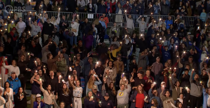 Hundreds of phone flashlights light up
